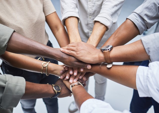 high angle shot of a group of unrecognisable businesspeople joining their hands together in a huddle jpg